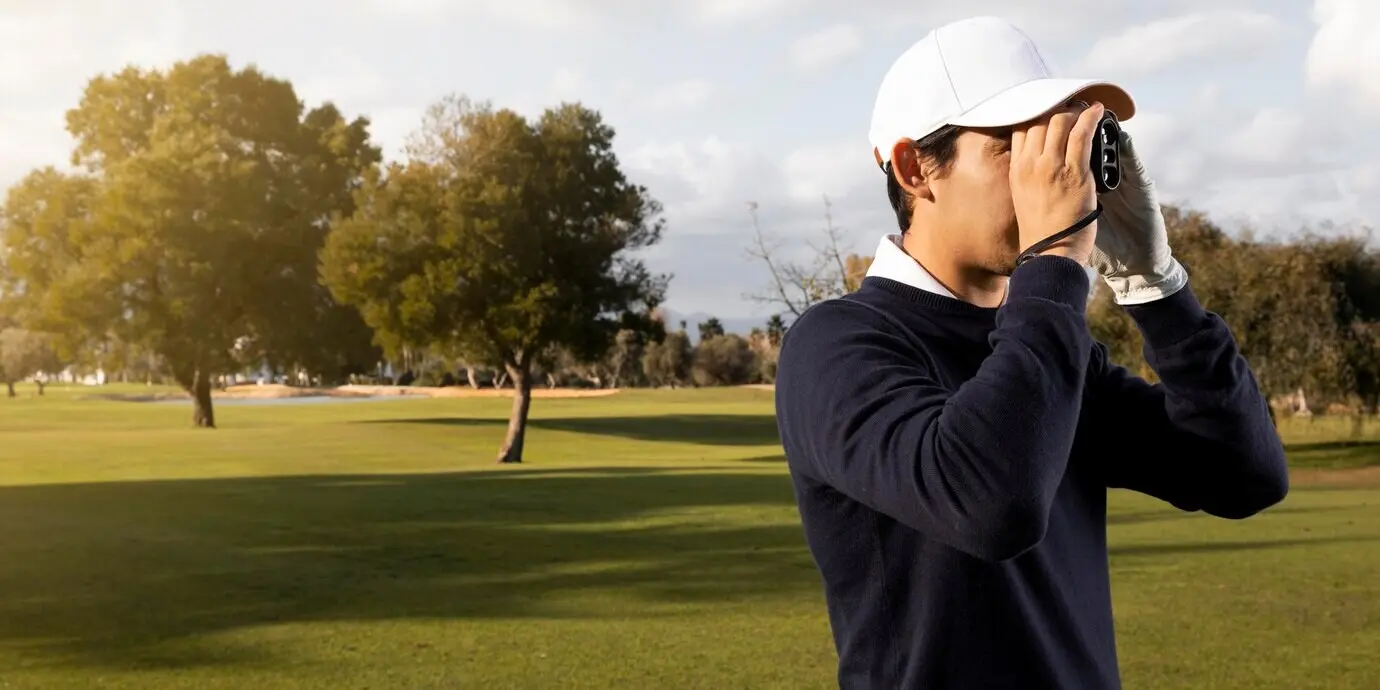 Side profile of a man with binoculars on the golf field.