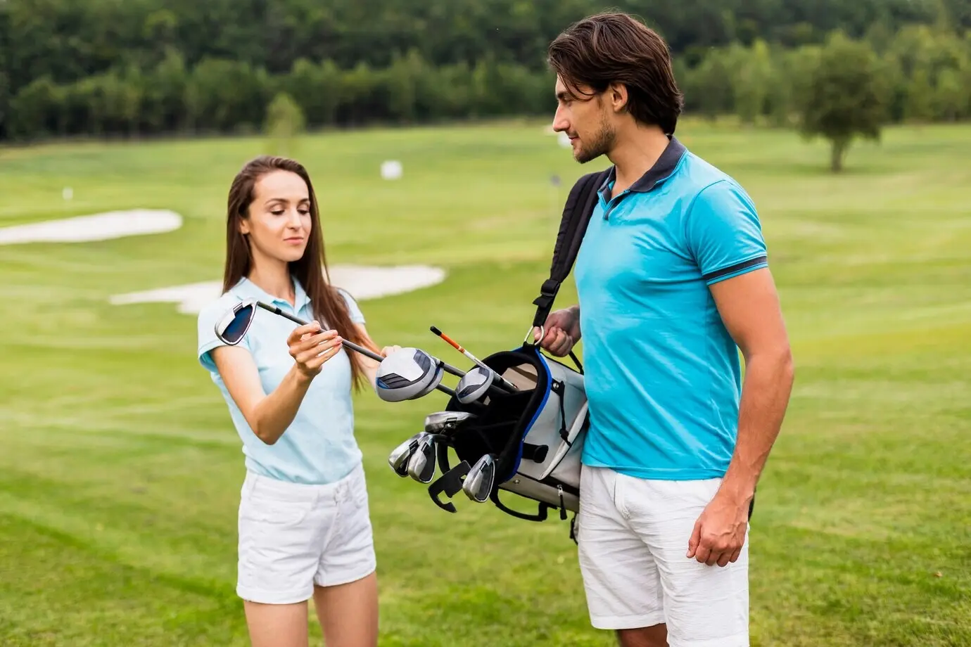 Frontal view of golf players looking at a club
