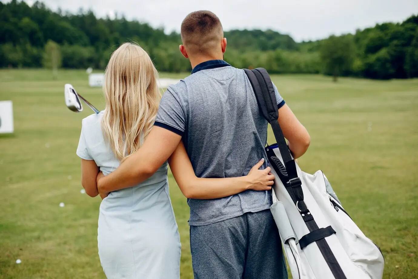 An attractive couple golfing on a golf course