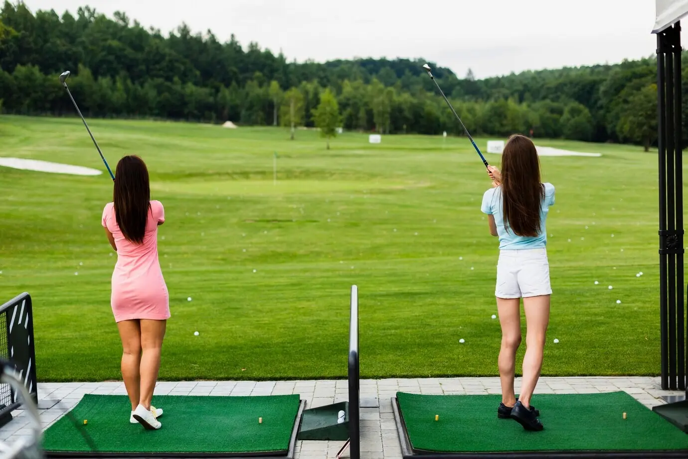 Back view of girls in casual wear at a golf course.